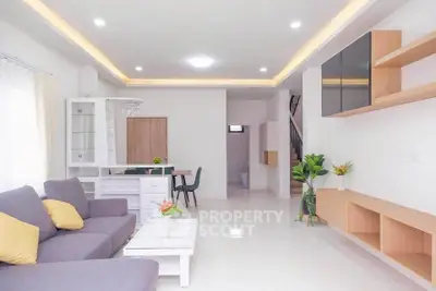 Modern living room with sleek furniture and bright lighting, showcasing a spacious and inviting atmosphere.