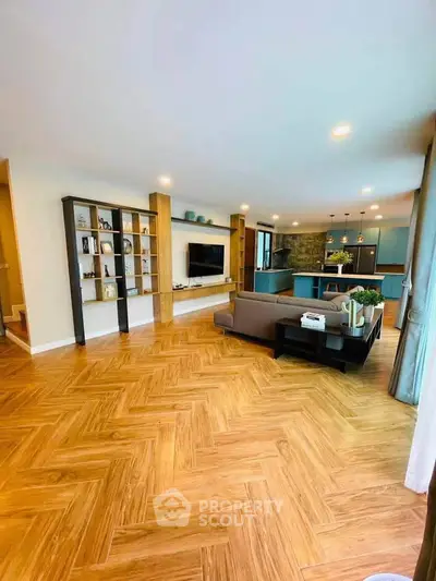Spacious open-plan living room with modern kitchen and stylish wooden flooring