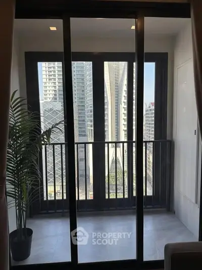 Modern apartment balcony with stunning city view and sleek sliding glass doors.