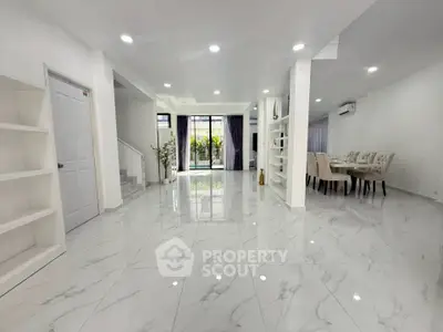 Spacious modern living and dining area with elegant marble flooring and natural light.