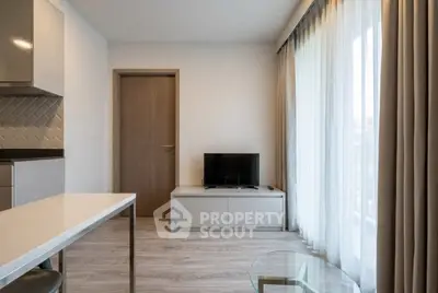 Modern living room with sleek furniture and large window for natural light.