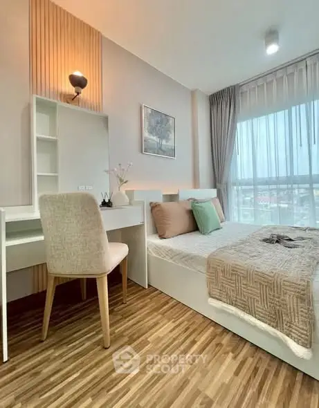 Modern bedroom with stylish decor and large window offering natural light and city view.