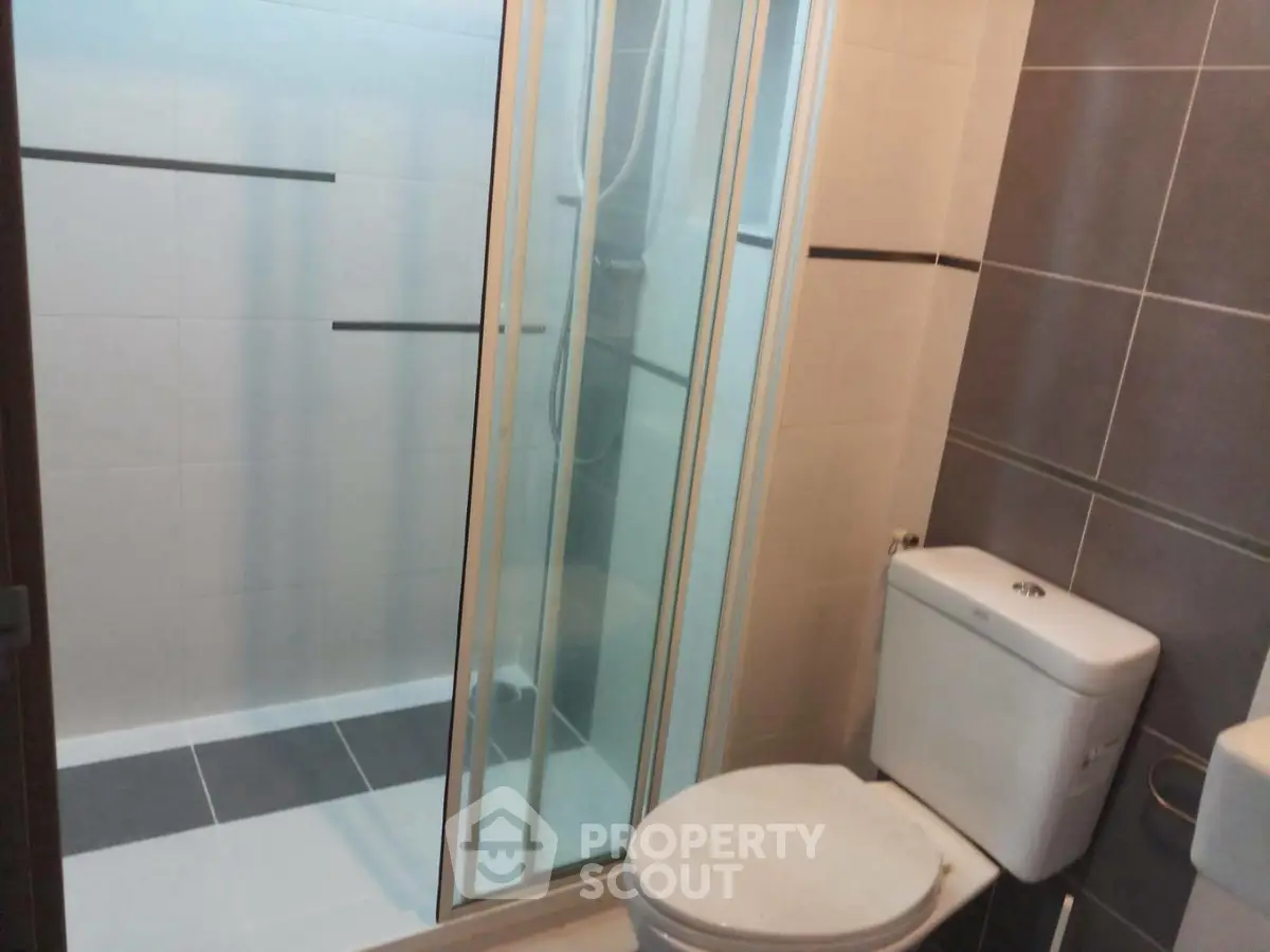Modern bathroom with sleek shower and toilet in contemporary design.