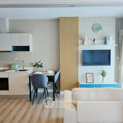 Modern living room with open kitchen, stylish decor, and cozy seating area.