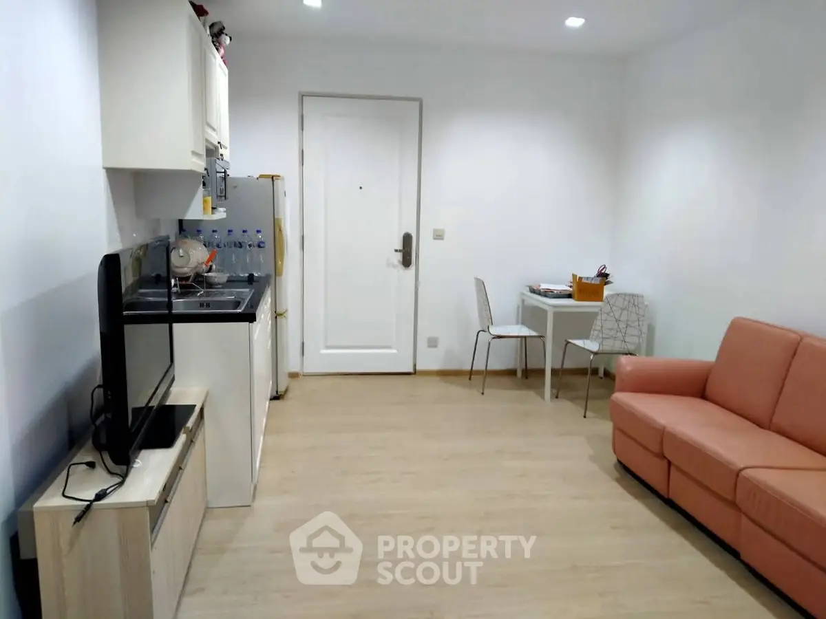 Cozy living room with compact kitchen and modern furnishings