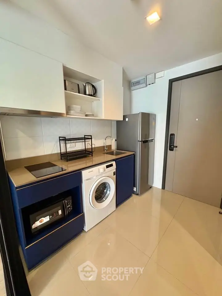 Modern kitchen with sleek appliances and washing machine in stylish apartment