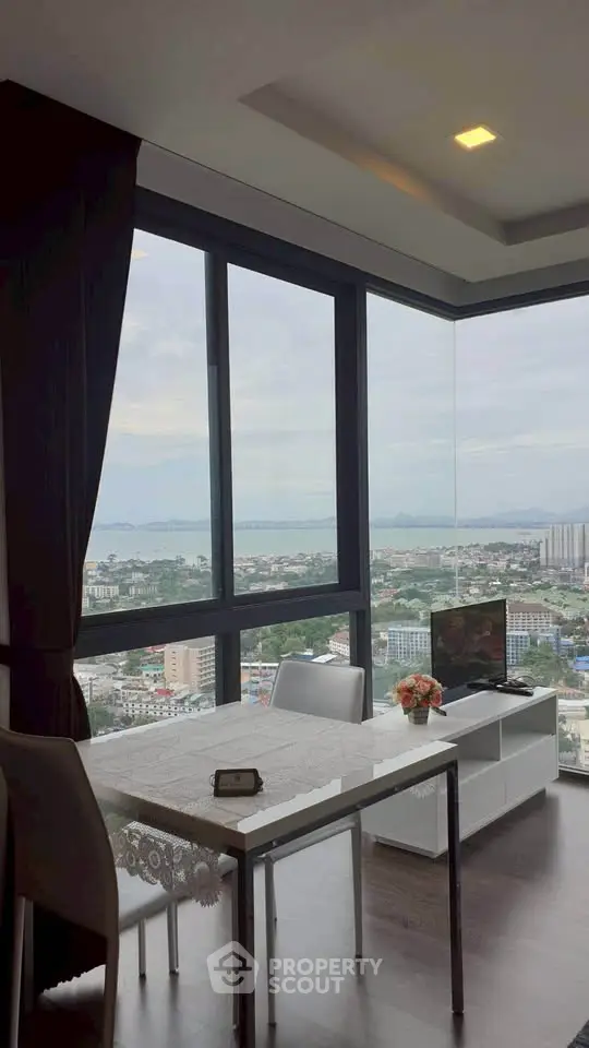 Stunning high-rise apartment with panoramic city and sea views, featuring modern dining area and floor-to-ceiling windows.