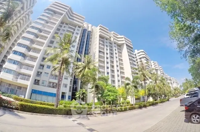 Stunning modern apartment complex with lush landscaping and palm trees under a clear blue sky.