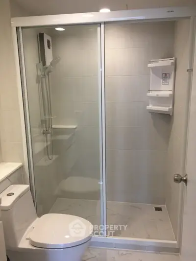 Modern bathroom with glass shower enclosure and sleek white fixtures