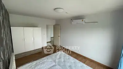 Spacious bedroom with modern air conditioning and ample wardrobe space.