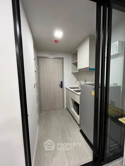 Modern compact kitchen with sleek design and efficient layout, featuring built-in appliances and stylish cabinetry.