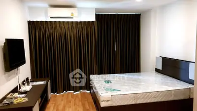 Modern bedroom with sleek furniture and large window with dark curtains.