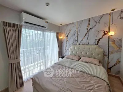 Luxurious bedroom with elegant marble accent wall and plush bedding, featuring natural light from large windows.