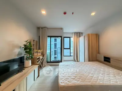 Modern bedroom with large window and stylish wooden furniture in a high-rise apartment.