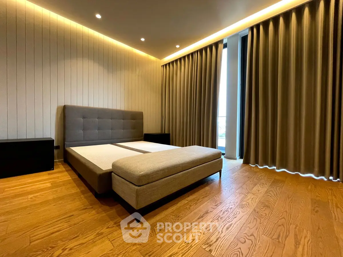 Spacious modern bedroom with elegant lighting and wooden flooring