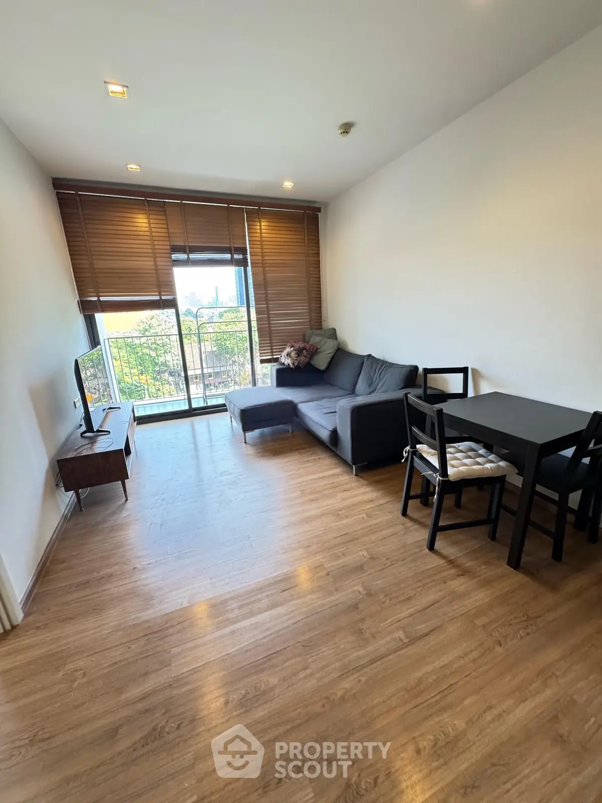 Modern living room with wooden flooring and balcony view