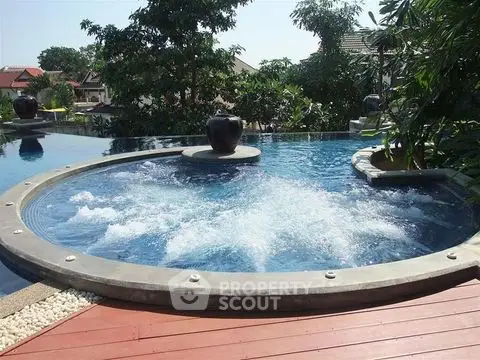 Luxurious outdoor pool with jacuzzi feature in a serene garden setting