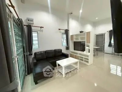 Spacious modern living room with sleek black sofa and entertainment unit