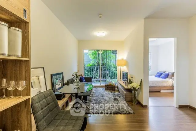 Modern living room with open layout and stylish decor, leading to a cozy bedroom with natural light.