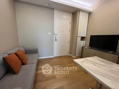 Cozy living room with modern decor, wooden flooring, and a sleek TV setup.
