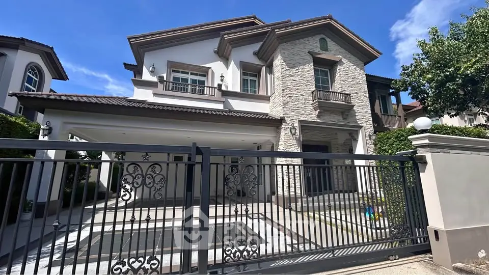 Elegant two-story house with stone facade and gated entrance