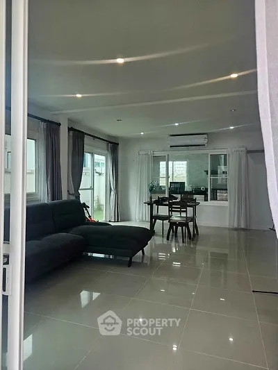 Spacious modern living room with sleek tile flooring and large windows for natural light.