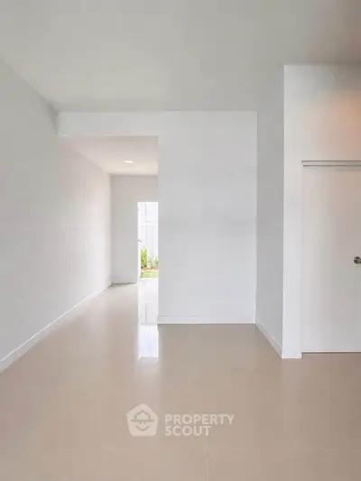 Spacious minimalist interior with neutral tones and natural light, perfect for modern living.