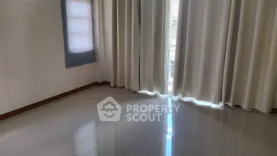 Spacious empty room with large windows and elegant curtains