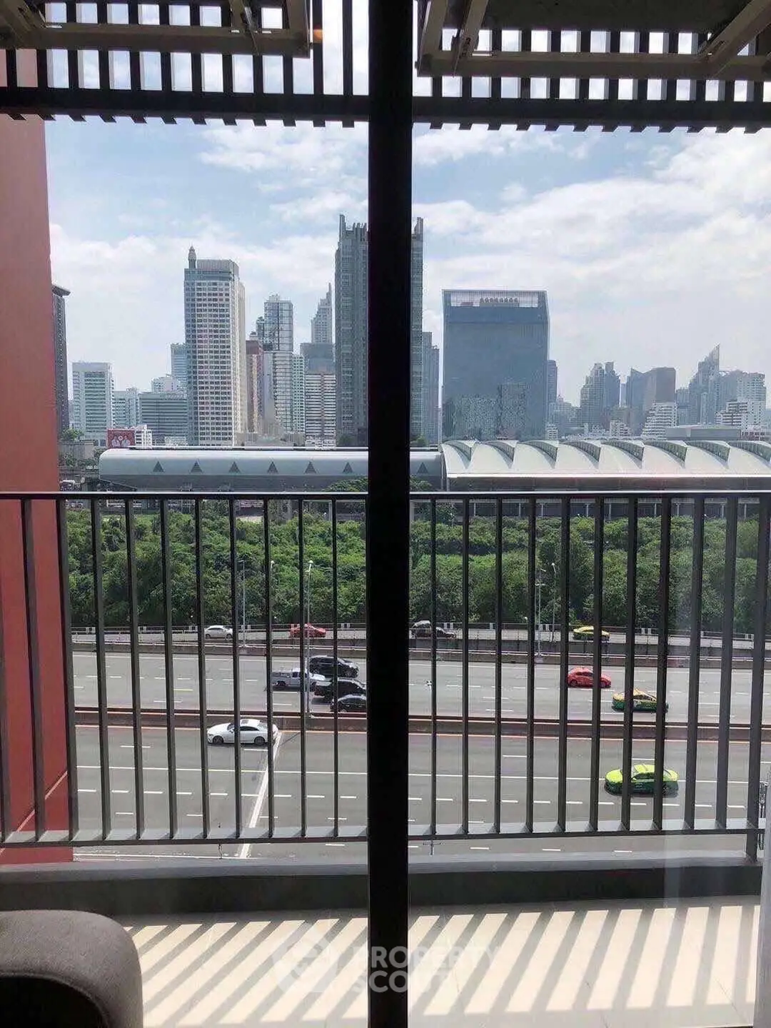 Stunning cityscape view from a modern balcony overlooking a busy highway and skyline.