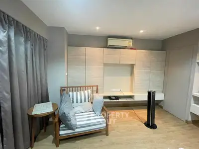 Modern living room with stylish furniture and air conditioning unit.