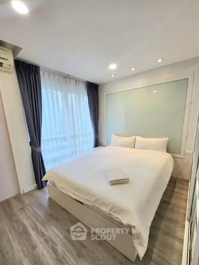 Modern bedroom with large window and elegant decor in a stylish apartment.