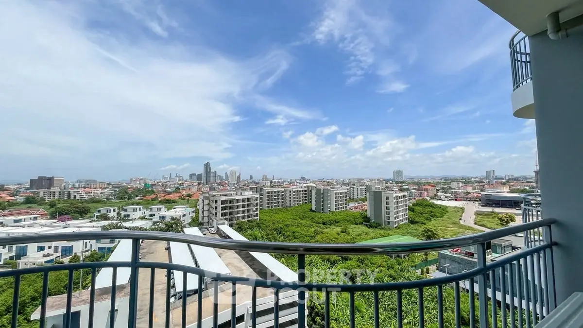 Stunning cityscape view from a high-rise balcony with clear blue skies.