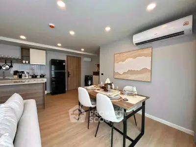 Modern open-plan living room and kitchen with stylish dining area and air conditioning.