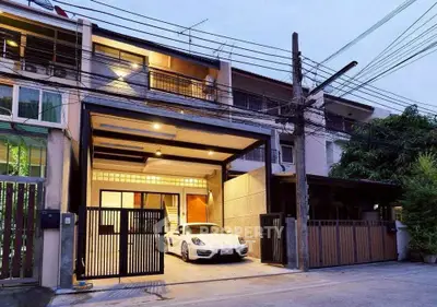 Modern townhouse with sleek garage and luxury car parked, showcasing urban living.
