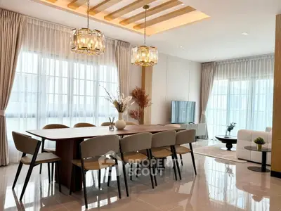 Luxurious modern living and dining area with elegant lighting and large windows.