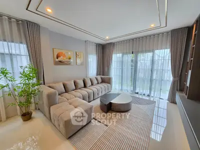 Elegant modern living room with plush sectional sofa and floor-to-ceiling windows.