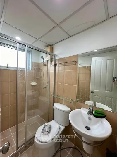 Modern bathroom with glass shower enclosure and sleek fixtures in a contemporary home.