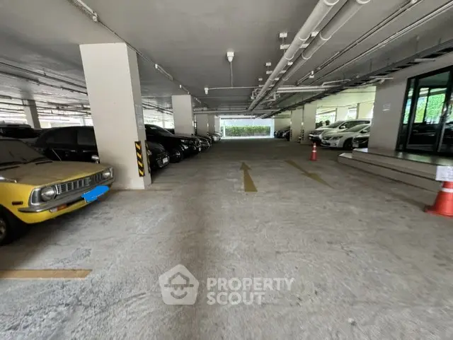 Spacious indoor parking area with multiple cars and clear directional arrows.