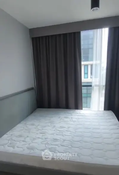 Modern bedroom with large window and stylish curtains in urban apartment