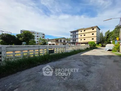 Charming residential street with modern apartment buildings and lush greenery.