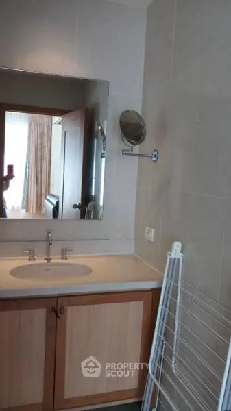 Modern bathroom with sleek vanity and wall-mounted mirror in a stylish apartment.