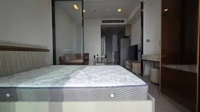 Modern bedroom with glass doors and stylish furniture in a contemporary apartment.