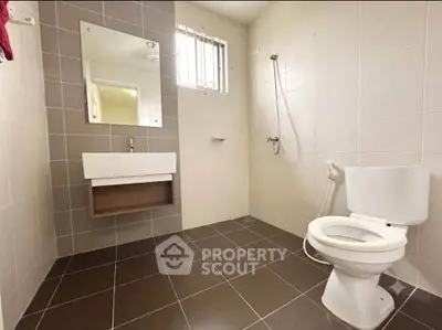Modern bathroom with sleek fixtures and neutral tiles, featuring a spacious shower area and contemporary design.