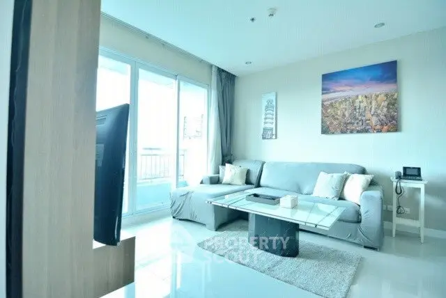 Modern living room with large windows and stylish decor in a bright apartment.