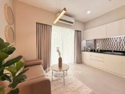 Modern living room with stylish decor and open kitchen layout, featuring natural light and contemporary design.