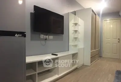 Modern living room with wall-mounted TV and sleek storage solutions.