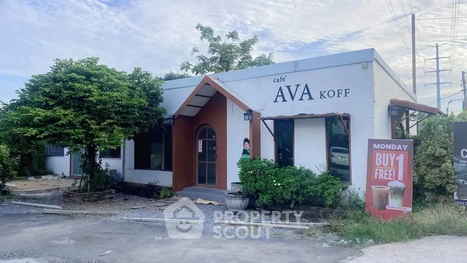 Charming cafe with inviting entrance and lush greenery, perfect for a cozy coffee break.