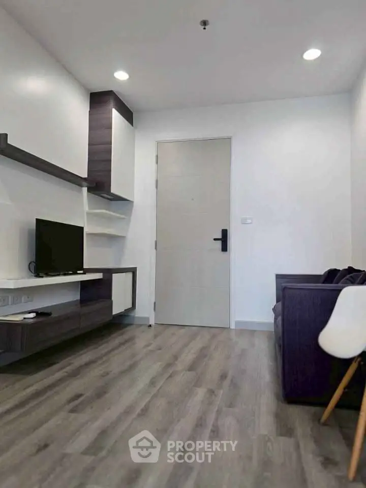Modern living room with sleek furniture and wooden flooring, perfect for cozy urban living.