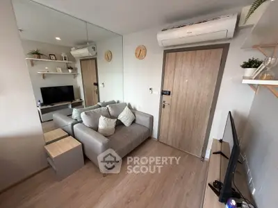 Modern living room with sleek design, featuring a cozy sofa, wall-mounted TV, and stylish decor.