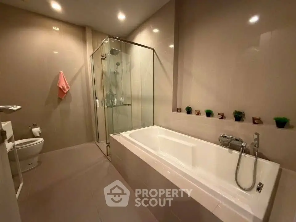 Luxurious bathroom with modern bathtub and glass shower enclosure, perfect for relaxation.